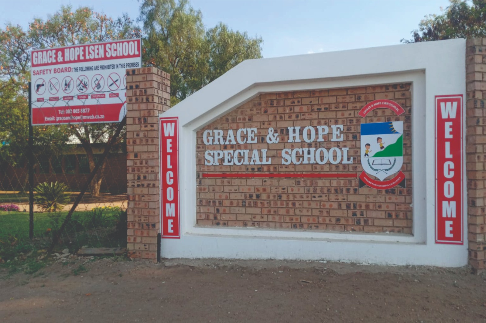 Grace & Hope Special School entrance wall branding with crest, welcome banners and safety board